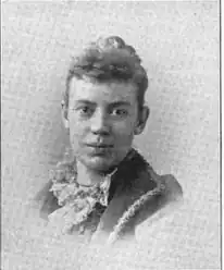 19th-century B&W portrait photo of a woman with her hair in an up-do, wearing a dark, fitted blouse.