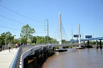 A new cable-stayed bridge with two towers hugs the bank of the Schuylkill River.