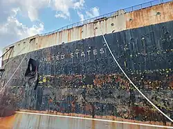 The rusting ship's name and bow.