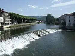 Colour photograph of a river obstructed by a 1–2 m high weir.