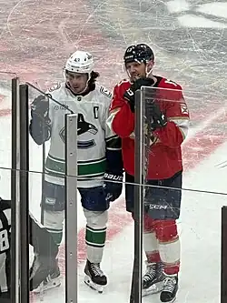 Sam Reinhart stands next to Quinn Hughes during a game against the Vancouver Canucks in November 2025.