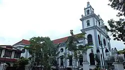 Northern flank of the church, with its façade and twin belfries to the right