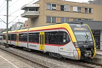 Three-section articulated electric train at a station platform
