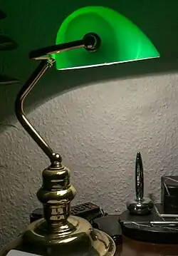 Banker's lamp turned on, in low light