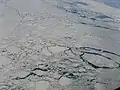 Aerial view showing an expanse of drift ice offshore Labrador (Eastern Canada) displaying floes of various sizes loosely packed, with open water in several networks of leads. (Scale not available.)