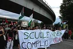 Italian protesters holding the banner and waving Palestine Flag