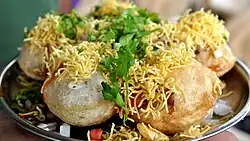 Small balls of thin dough are topped with sev and coriander leaves. Chutney is in the filling.