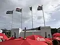 Red umbrellas with "sex work is work" written on them, against the backdrop of the SA flags outside South Africa's Parliament in Cape Town