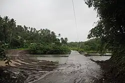 A bridge in Siha flooded by a river during the onslaught of Bualoi in Eastern Samar.