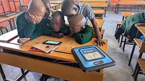 Elementary students in Lesotho access content on the SolarSPELL digital library through their respective tablet.