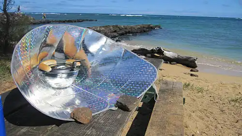 Hot dogs being cooked with a solar funnel cooker