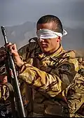 A soldier assembling and disassembling his gun parts with closed eyes