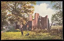 A picture postcard showing Someries Castle in the early 20th Century. A man sits while another man stands on a grass field in the center foreground, the castle ruins are in the background showing the surrounding fields, shrubs, trees and greenery, with a lady walking on a path on the left of the picture.