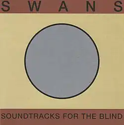 A gray circle with a black outline sits on a cardstock, yellow-beige background. The upper and bottom portions of the cover are dark reddish-brown, with "SWANS" written in large black letters at the top. Below the circle, "SOUNDTRACKS FOR THE BLIND" appears in matching letters on the lighter background.