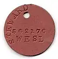 One of the two compressed asbestos identity discs issued by the South African Navy during World War II with rank, surname, initials, force number and religious affiliation