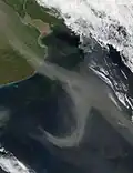 A pale brown plume of dust sweeps out of Argentina's Pampas.