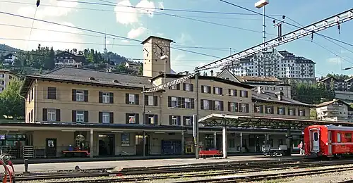 Wide four-story building with hip roof and clock tower