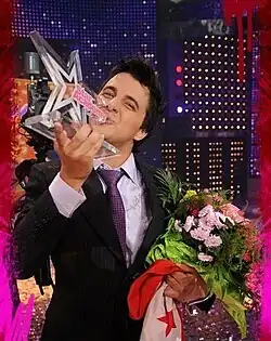 Nader Guirat winner of Star Academy 5 carrying the Tunisian flag and the trophy on stage at the show's finale on May 23, 2008