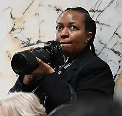 Irungu holding a Nikon camera