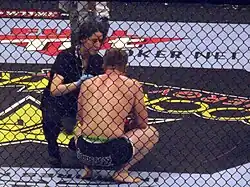 Image 45A ring-side doctor attends to a fighter following a loss. (from Mixed martial arts)