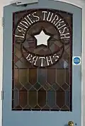 Stained glass door panel leading to 1st floor baths