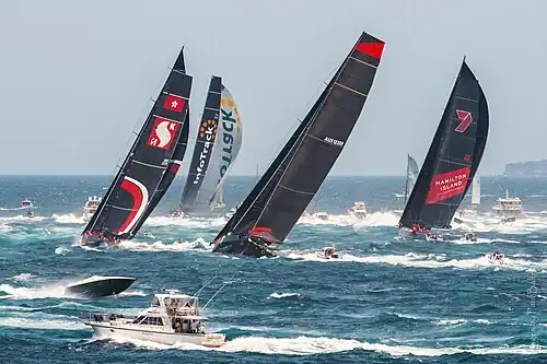 black and red boats in the middle of the waves of the blue sea