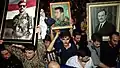 Syrians holding portraits of the Assad family