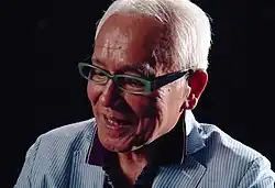 Portrait of Susumu Kurobe wearing glasses and a collared shirt.