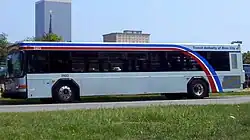 White bus with curved red, white and blue stripes