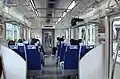Interior of a 50090 series EMU on a TJ Liner service, showing forward-facing transverse seating configuration
