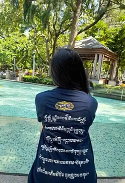 A woman wearing a t-shirt with Aksara Kawi