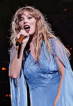 Swift performing onstage wearing a rhinestoned outfit