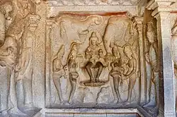 Square, carved wall with a number of figures