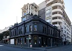 view of small old pub and large modern apartment block