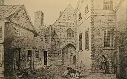 A black and white pencil drawing of some stone and brick buildings forming a small complex from a short distance away. The buildings each have a door and some windows, with children in the courtyard in front.