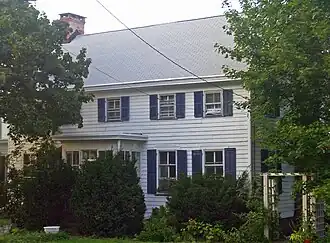 Front view of the Homestead, with trees on either side.