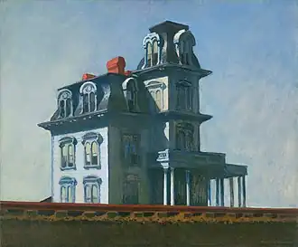 A Victorian house is seen partially obscured by train tracks in the foreground