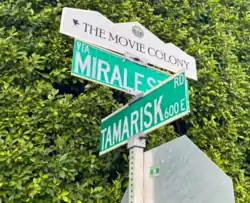 A picture of the official "The Movie Colony" street sign that appears above the street signs for Miraleste and Tamarisk in Palm Springs