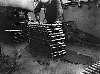 A stack of 14 linked rounds of naval pom-pom ammunition.