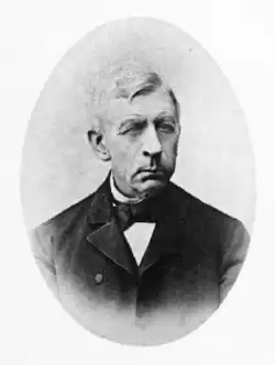 A black and white photograph of an elderly man in a suit