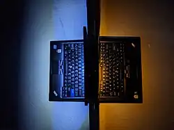 Two ThinkPads each with a ThinkLight. The left one is a white LED, the right one is an amber LED.