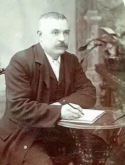 Thomas Grey c. 1899 with a pen and paper