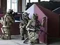 Three airsoft team members defending an area during an indoor CQB game