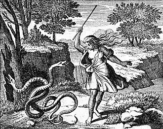 A person with flowing robes holding a staff strikes two intertwined snakes on the ground