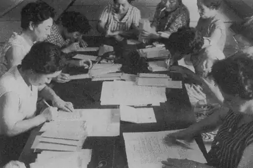 Women sitting around a table preparing documents