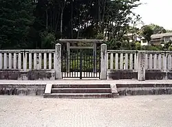 Torii behind concrete fence.