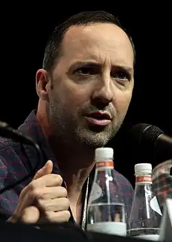 A photograph of a balding man, smoldering to something offscreen.