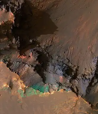 South rim of Coprates Chasma, image is about a kilometer wide. With enhanced IR colors, we see a portion of the very top of the south wall of the canyon, looking down onto the steep upper slopes of the canyon.