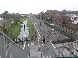 Tram stop, railway lines and River Leen seen from bridge looking north