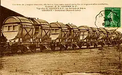 A postcard, with franked stamp, showing a row of railway wagons. Each wagon carries two large wine casks, bearing the name 'GRANDIN'